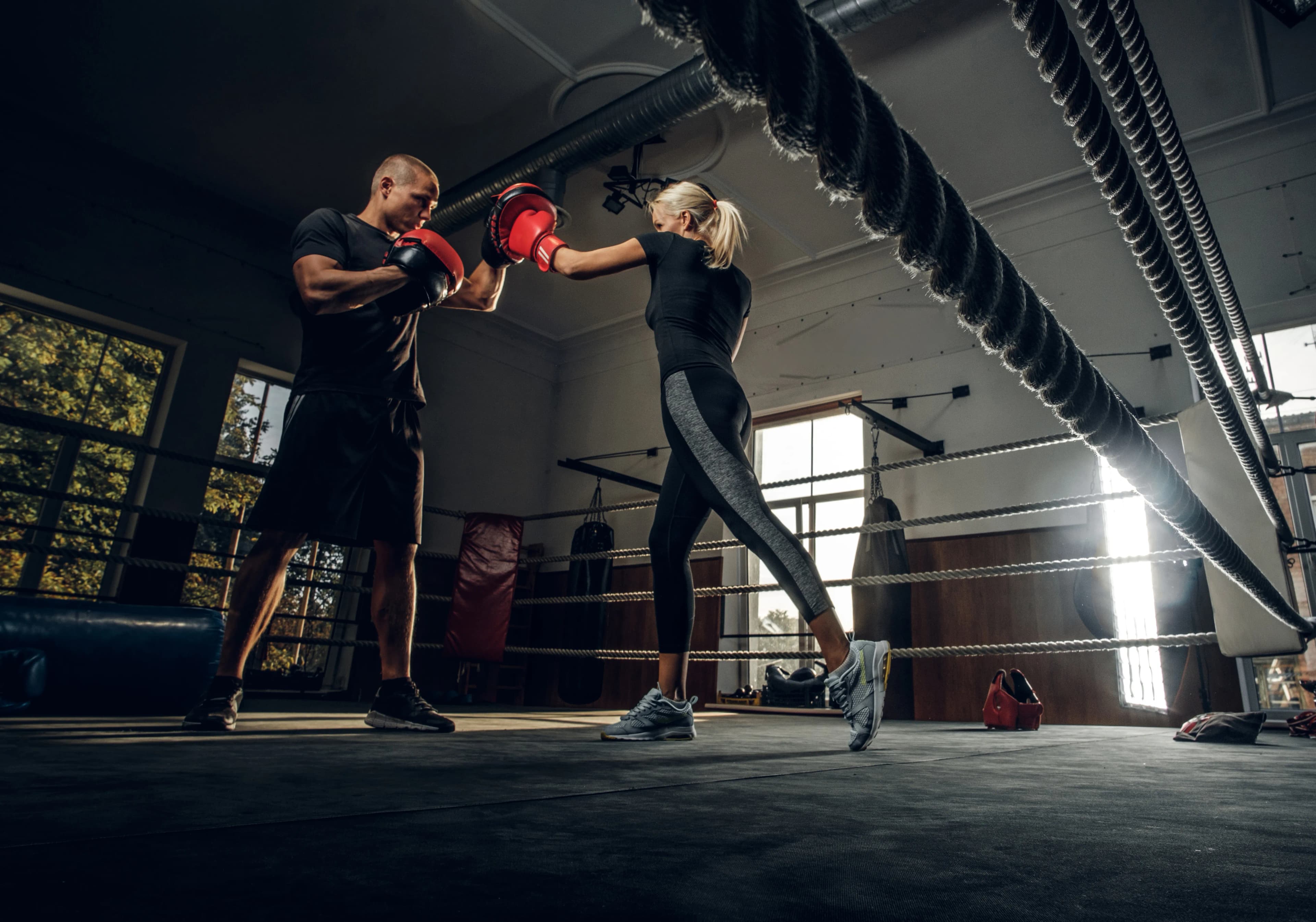 boxing trainer his new student have sparring ring wearing boxing gloves